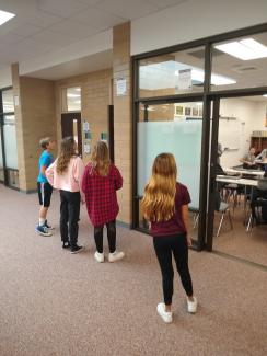 Students run into the hall to find part of the story
